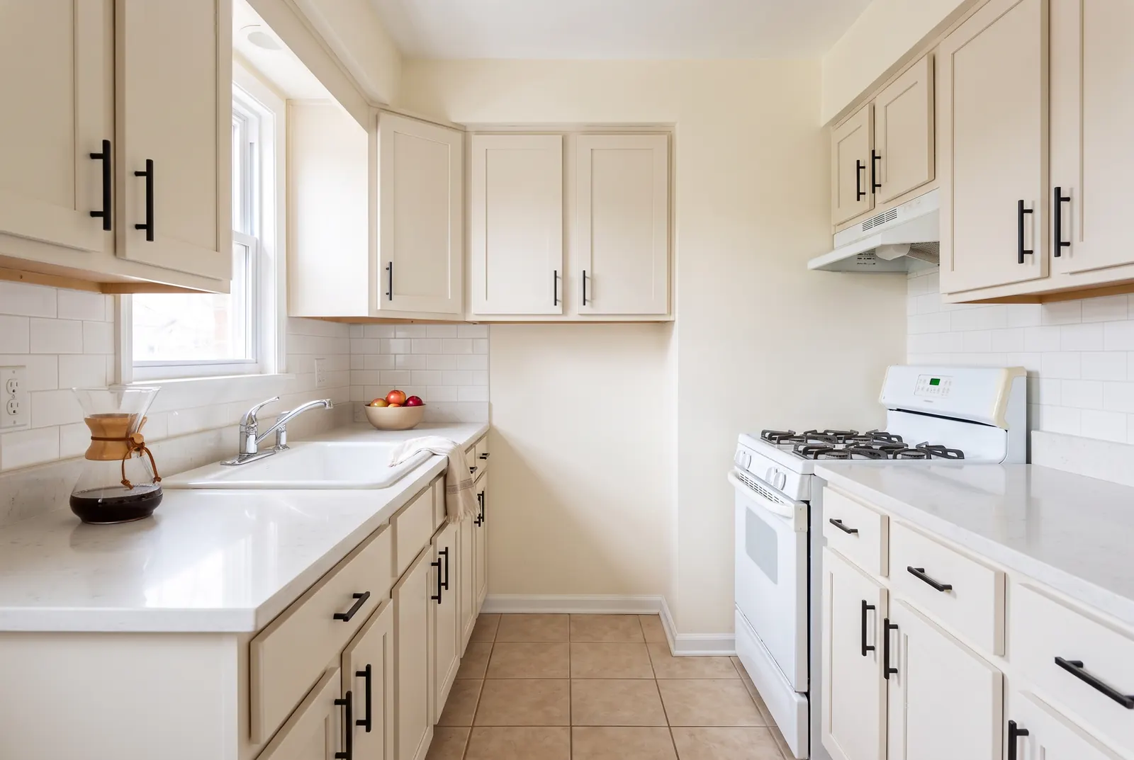 The same kitchen after a minor remodel with painted cabinet fronts and new counters