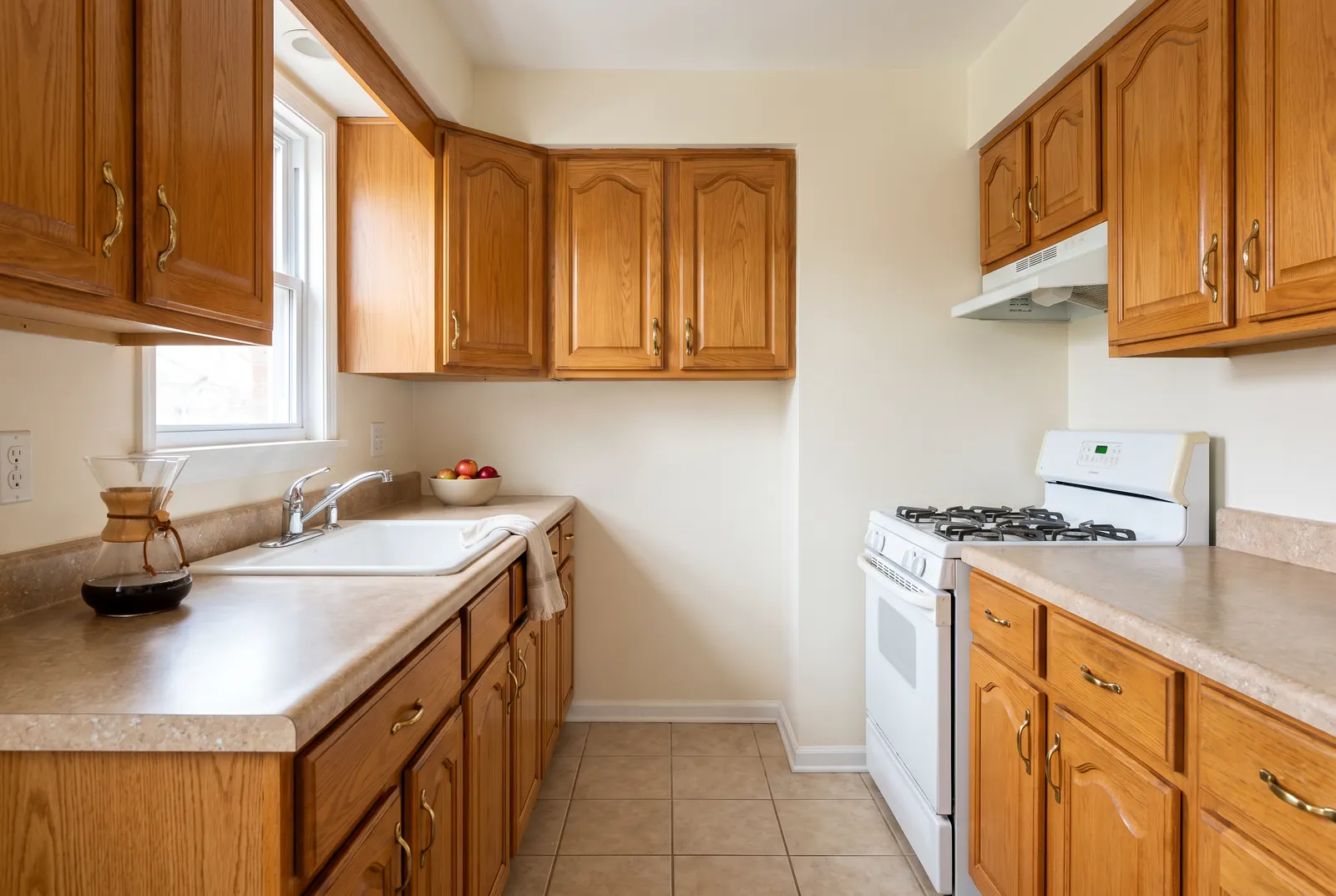 A dated kitchen with honey-oak cabinets and laminate counters