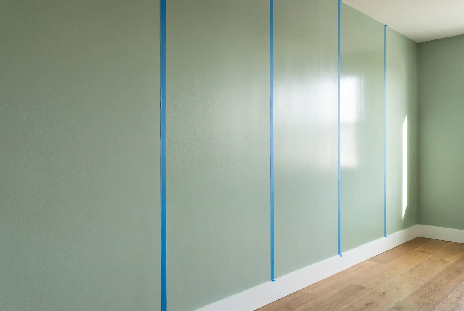 Four wall panels in the same color, from matte to semi-gloss, reflecting window light