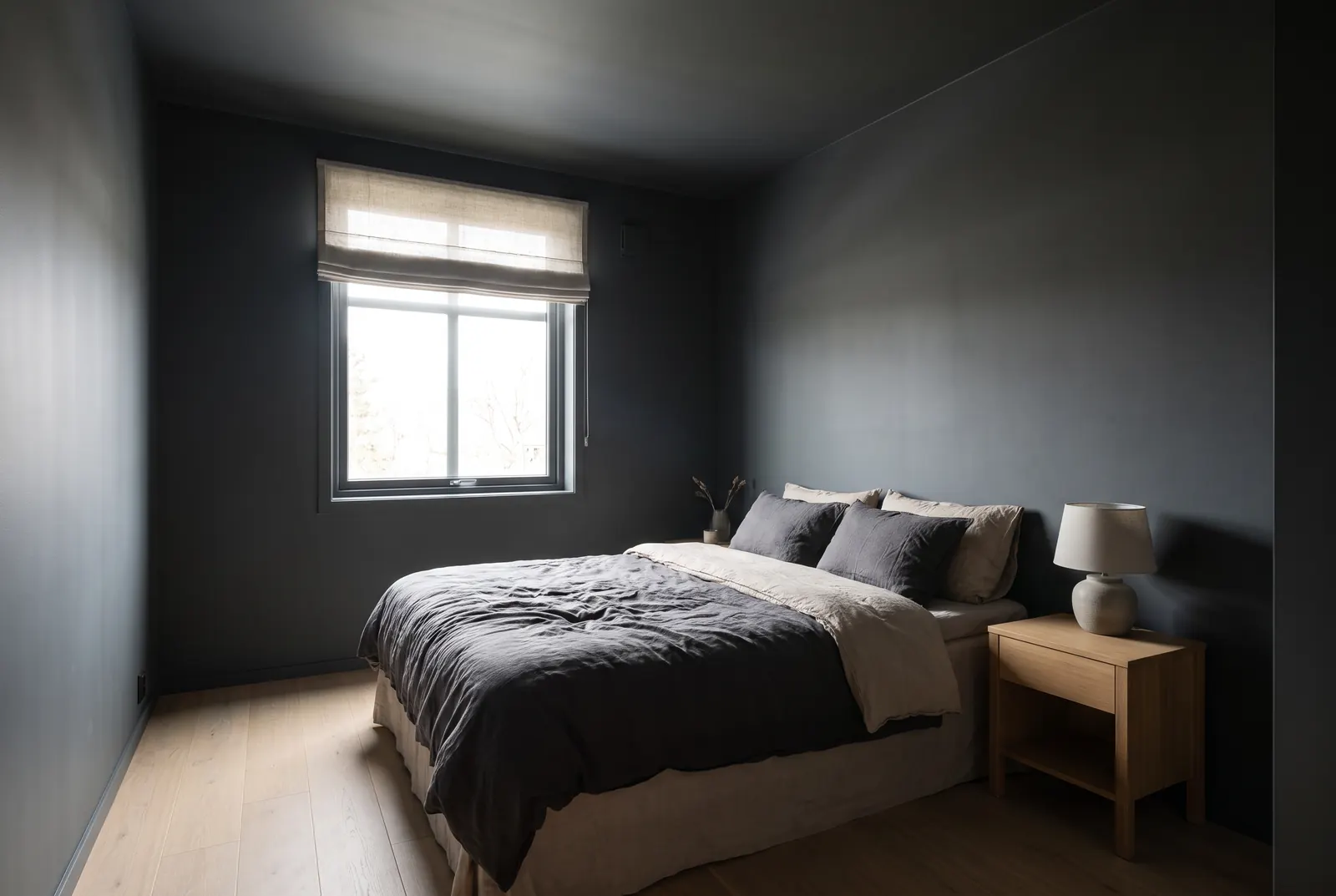 A small bedroom with dark charcoal walls and ceiling